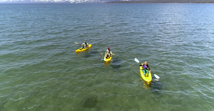 three kayakers in the lake wearing wader skins 